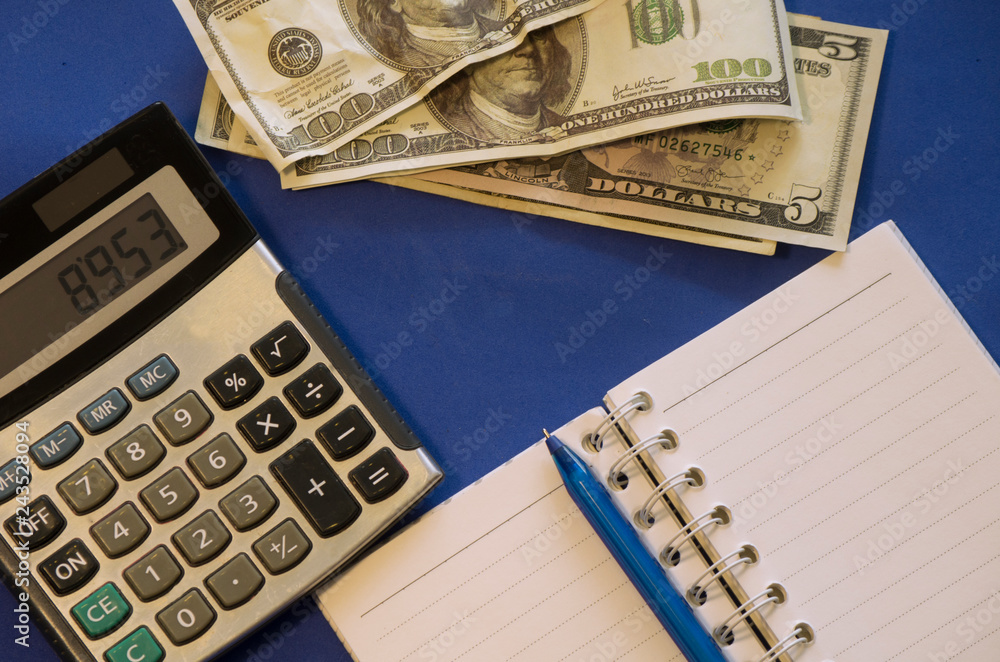 money, notebook, calculator are on a blue background money, notebook, calculator are on a blue background