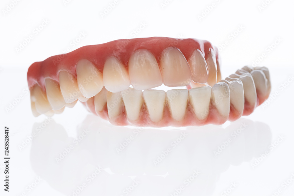 Obraz premium Two Dental prosthesis from ceramic and artificial gums, photographed on a white background with reflection