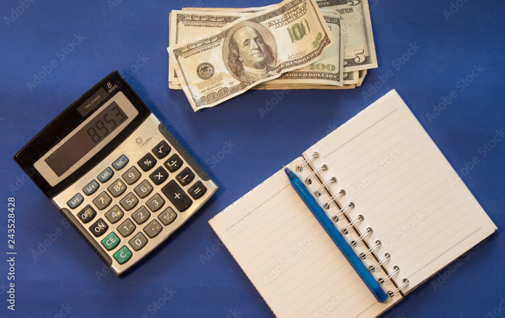 money, notebook, calculator are on a blue background money, notebook, calculator are on a blue background