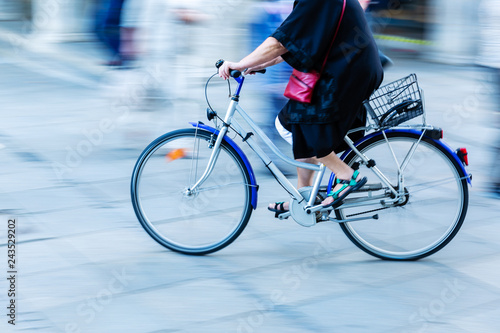 older woman rides a bicycle in the city
