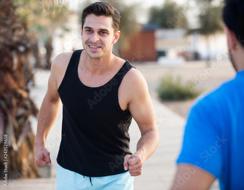 Portrait of adult man who is jogging with friend © JackF