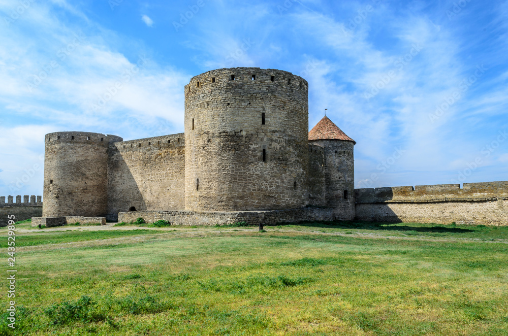 Medieval castle by the sea, surrounded by green grass. Krupost, fortification in Eastern Europe, Ukraine, Odessa region. Belgorod-Dniester fortress. The dwelling of knights and lords. Ackermann.