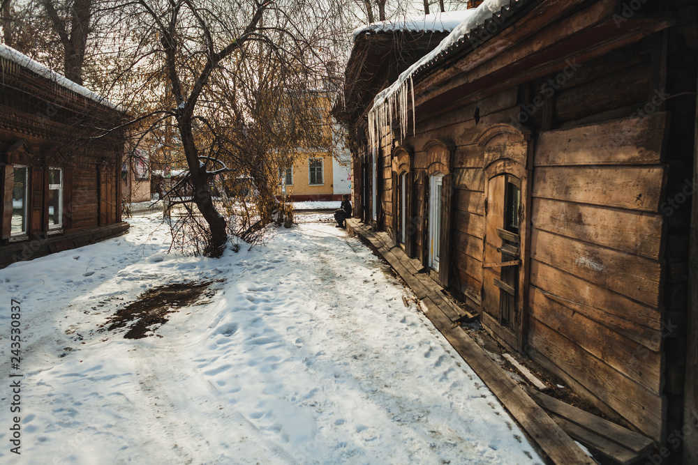 a wooden house with icicles in spring in a historical part of a siberian city