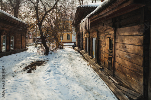 a wooden house with icicles in spring in a historical part of a siberian city