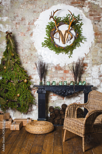 an armchair at a chimney and a sprice tree with horns on a wall photo