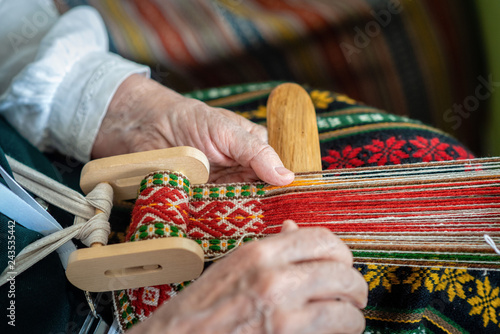 Woman working at the weaving loom. Traditional Ethnic craft of Baltic. - Image photo