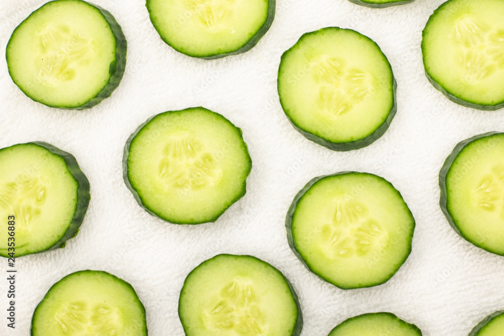 Background from sliced ​​cucumbers on a white towel
