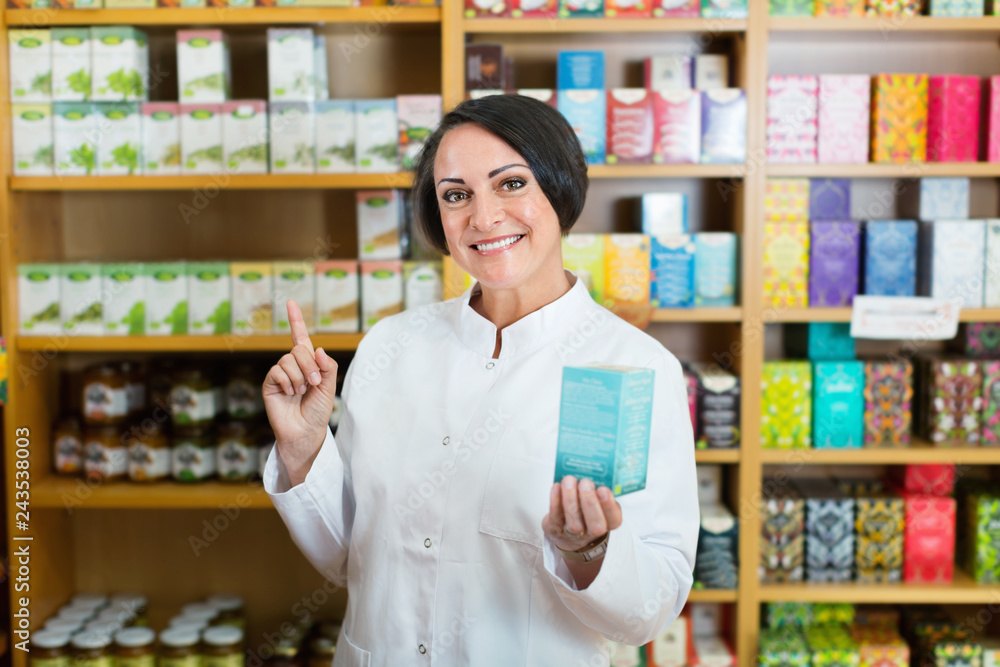 Woman in white coat promoting food additive goods in carton in drugstore