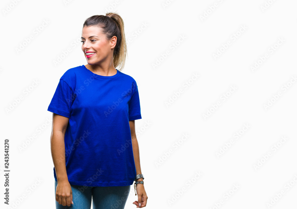 Young beautiful woman wearing casual blue t-shirt over isolated background looking away to side with smile on face, natural expression. Laughing confident. Young beautiful woman wearing casual blue t-shirt over isolated background looking away to side with smile on face, natural expression. Laughing confident.