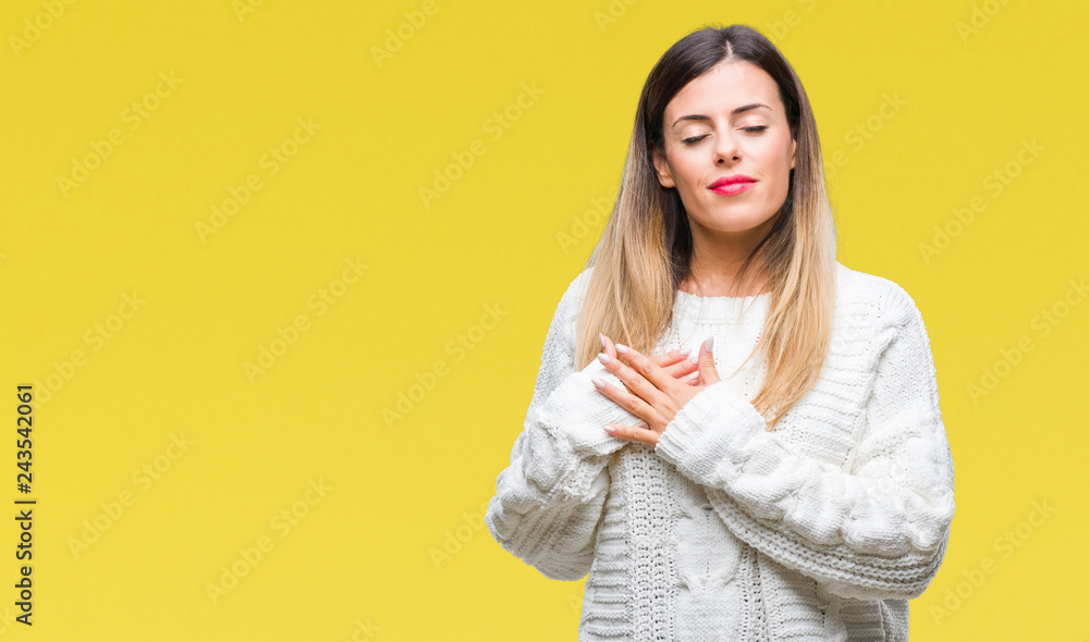Young beautiful woman casual white sweater over isolated background smiling with hands on chest with closed eyes and grateful gesture on face. Health concept. Young beautiful woman casual white sweater over isolated background smiling with hands on chest with closed eyes and grateful gesture on face. Health concept.