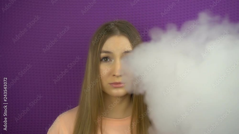 The reaction of beautiful girl to smoke in slow motion. The reaction of beautiful girl to smoke in slow motion.