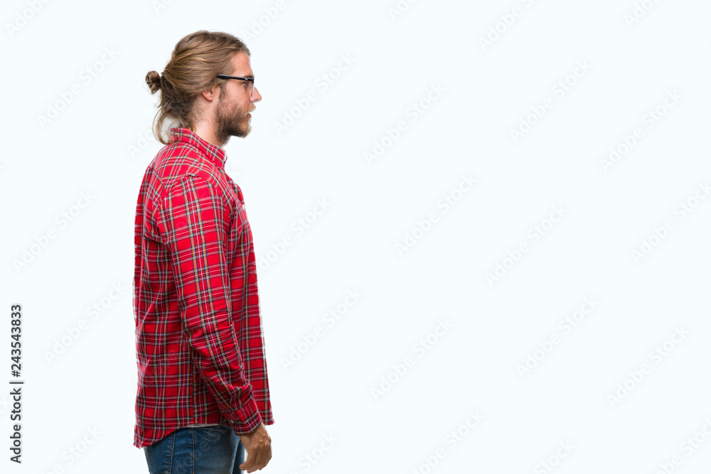 Young handsome man with long hair wearing glasses over isolated background looking to side, relax profile pose with natural face with confident smile.