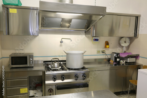 industrial kitchen with a large saucepan on the stove and the ta