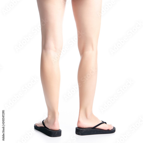 Woman legs in black flip flops on white background isolation, back view