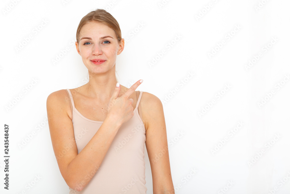 Portrait of happy surprised young woman model indicates with fore finger shows place for your advertisement or promotional text. Portrait of happy surprised young woman model indicates with fore finger shows place for your advertisement or promotional text.