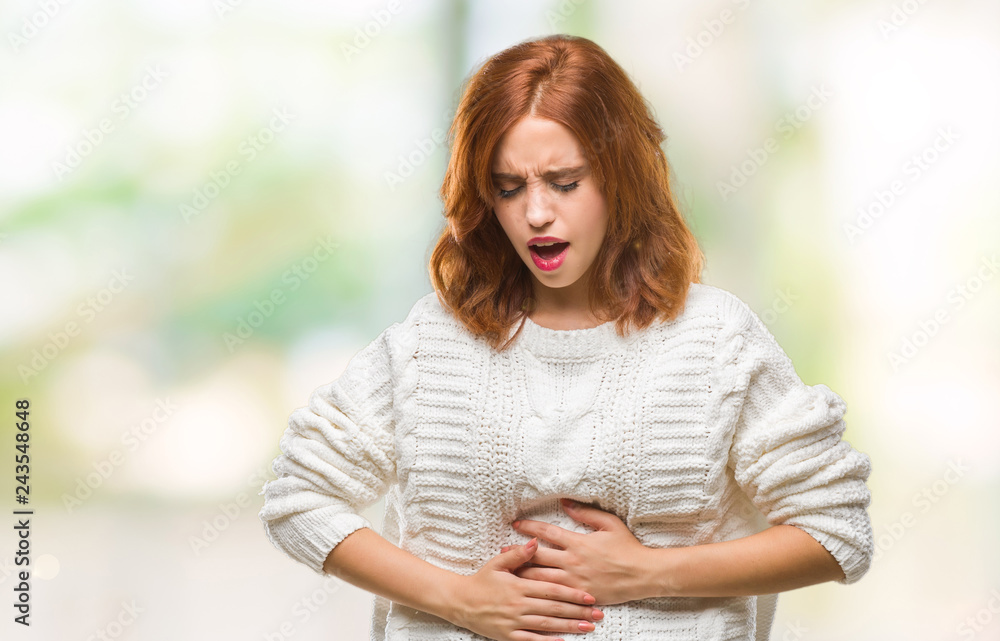 Obraz premium Young beautiful woman over isolated background wearing winter sweater with hand on stomach because indigestion, painful illness feeling unwell. Ache concept.