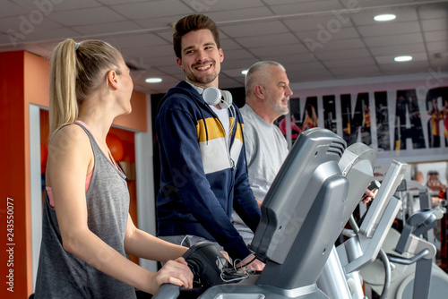 Smiling people running on a treadmill in the health club © Drpixel