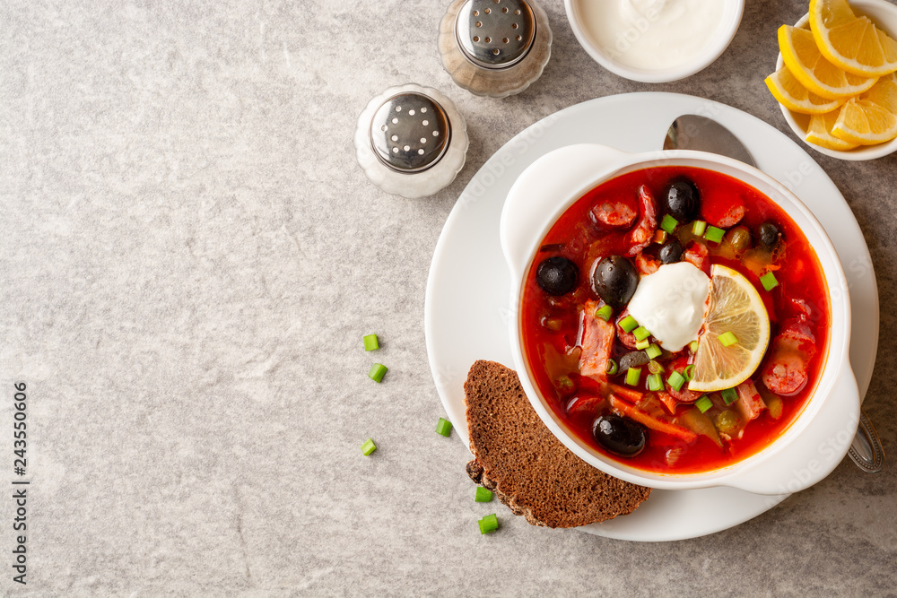 Traditional Russian meat soup Solyanka in bowl on grey stone background. Top view. Copy space. Traditional Russian meat soup Solyanka in bowl on grey stone background. Top view. Copy space.
