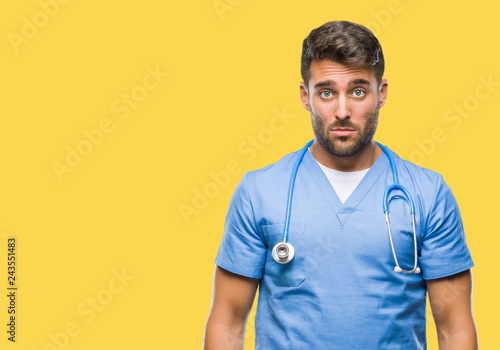 Young handsome doctor nurse man over isolated background depressed and worry for distress, crying angry and afraid. Sad expression.