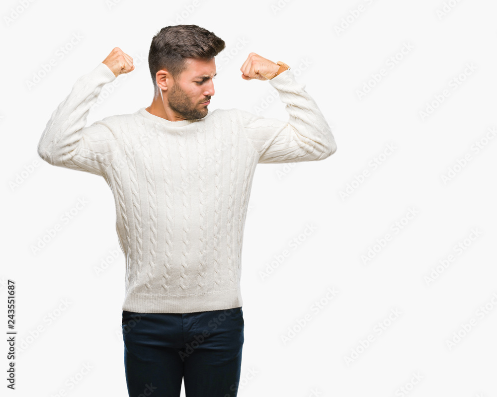 Young handsome man wearing winter sweater over isolated background showing arms muscles smiling proud. Fitness concept. Young handsome man wearing winter sweater over isolated background showing arms muscles smiling proud. Fitness concept.