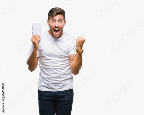 Young handsome man holding notebook over isolated background screaming proud and celebrating victory and success very excited, cheering emotion