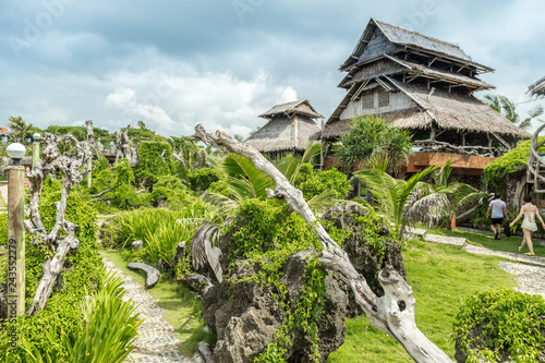 Bamboo houses green plants on Crystal Cove small island near Boracay island in the Philippines