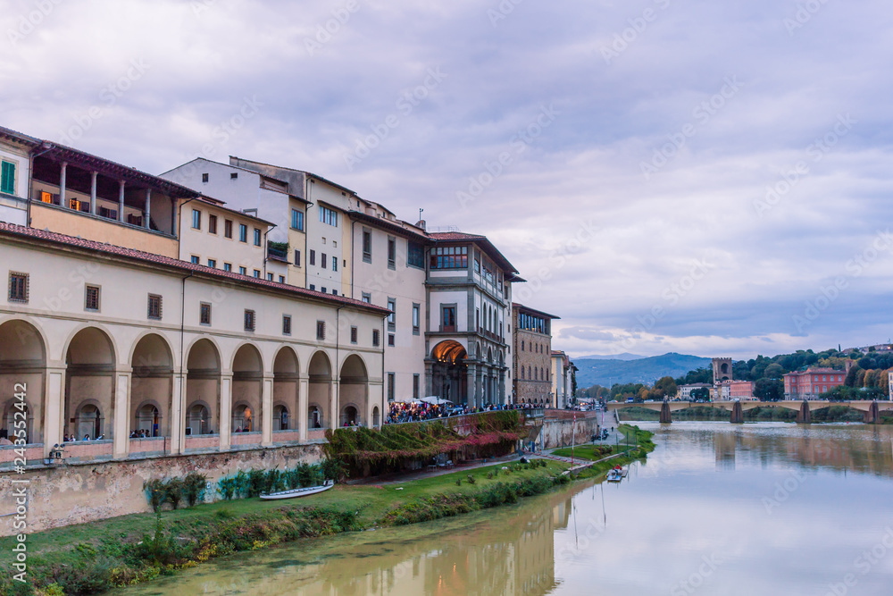 Colorful old buildings on the bank of Arno river in Florence, Italy with reflection in water. Medieval architecture