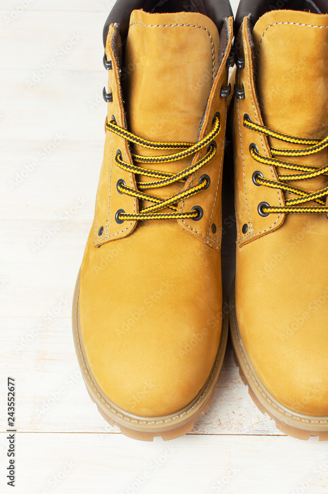 Close-up Yellow men's work boots from natural nubuck leather on wooden  white background. Trendy casual shoes, youth style. Concept of advertising  autumn winter shoes, sale, shop. foto de Stock | Adobe Stock