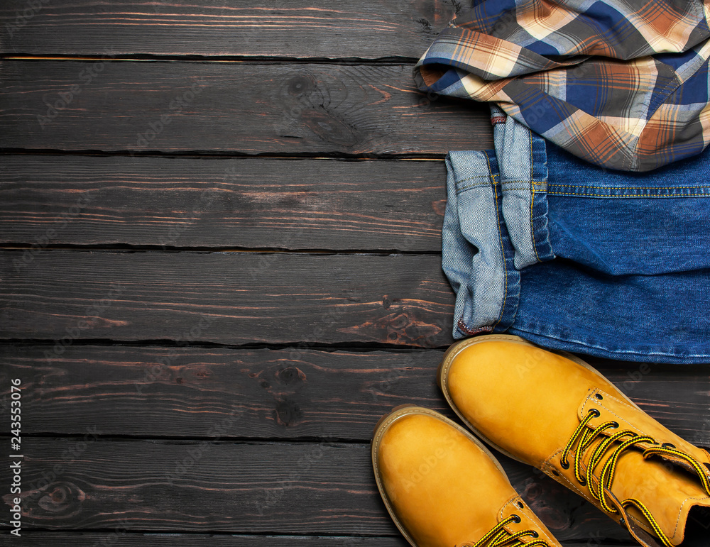 Men's casual wear, yellow work boots from natural nubuck leather, blue  jeans, checkered shirt and brown