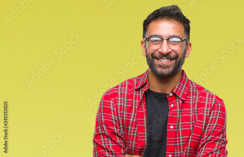 Adult hispanic man wearing glasses over isolated background happy face smiling with crossed arms looking at the camera. Positive person.