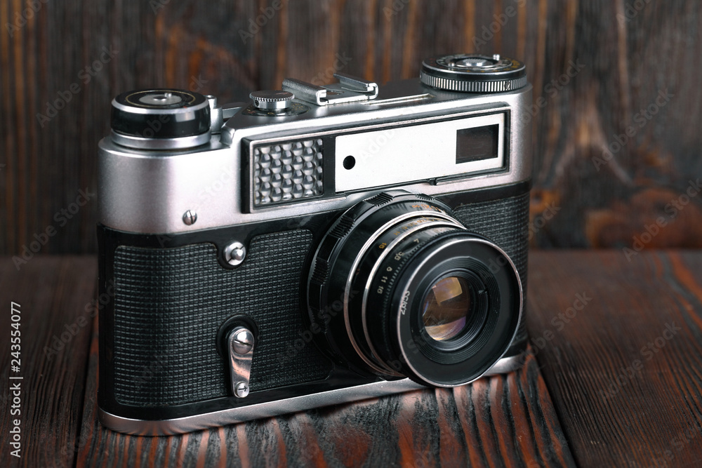 The old rangefinder camera on a brown wooden background.
