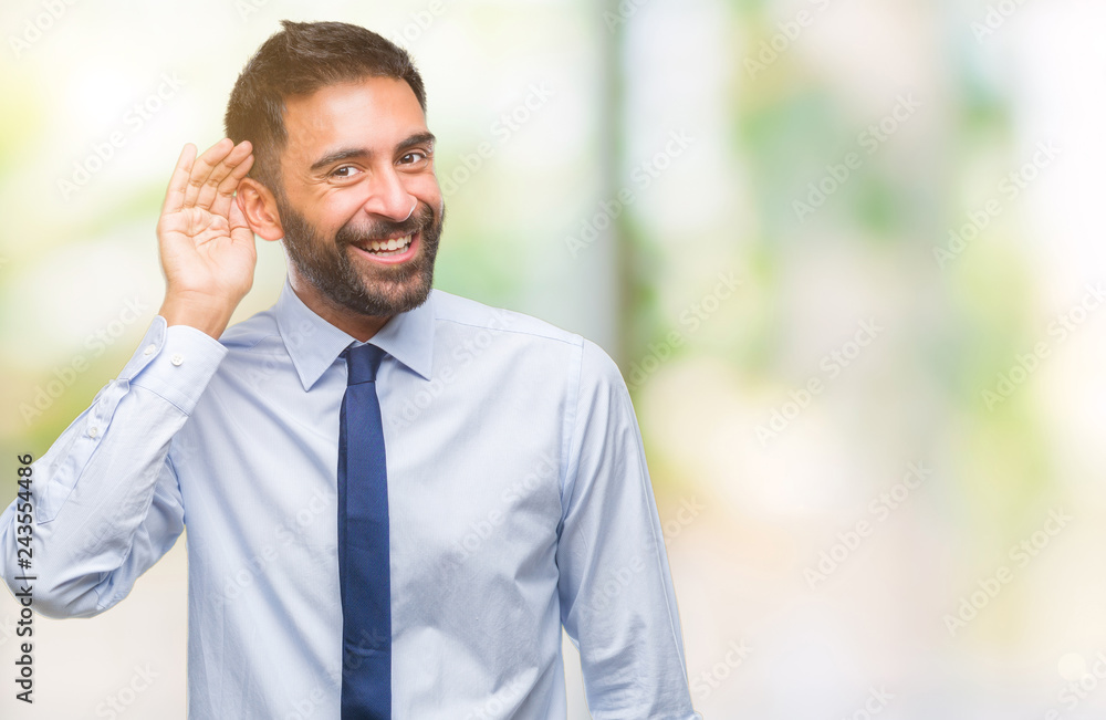 Adult hispanic business man over isolated background smiling with hand over ear listening an hearing to rumor or gossip. Deafness concept. Adult hispanic business man over isolated background smiling with hand over ear listening an hearing to rumor or gossip. Deafness concept.