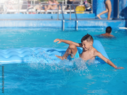 Smiling Caucasian boy having fun in swimming pool at resort on family vacation. © Artem