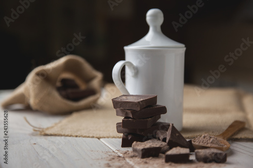 Foto Taza con chocolate caliente en invierno y algunos trozos de chocolate puro