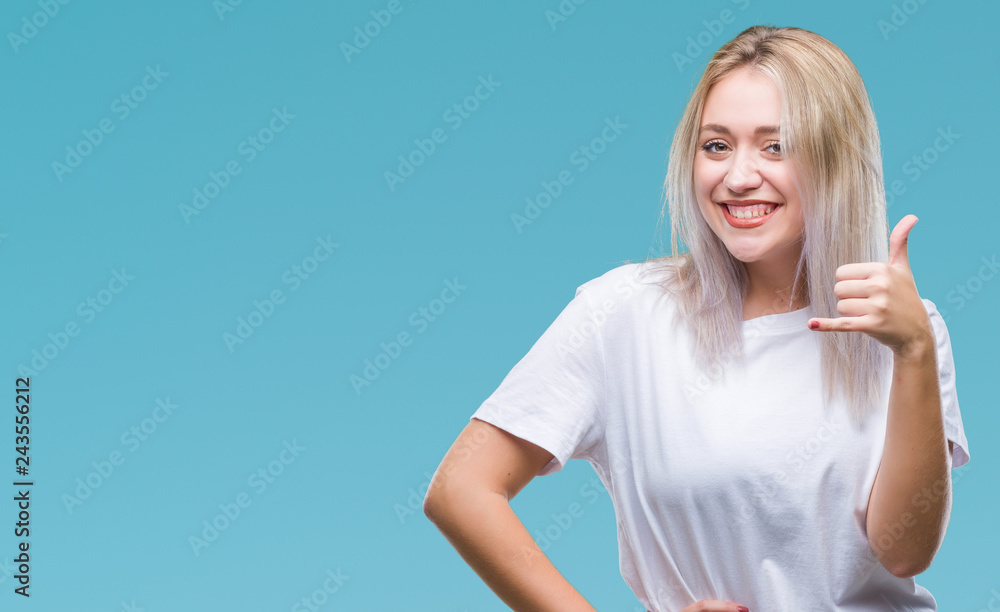 Young blonde woman over isolated background smiling doing phone gesture with hand and fingers like talking on the telephone. Communicating concepts. Young blonde woman over isolated background smiling doing phone gesture with hand and fingers like talking on the telephone. Communicating concepts.