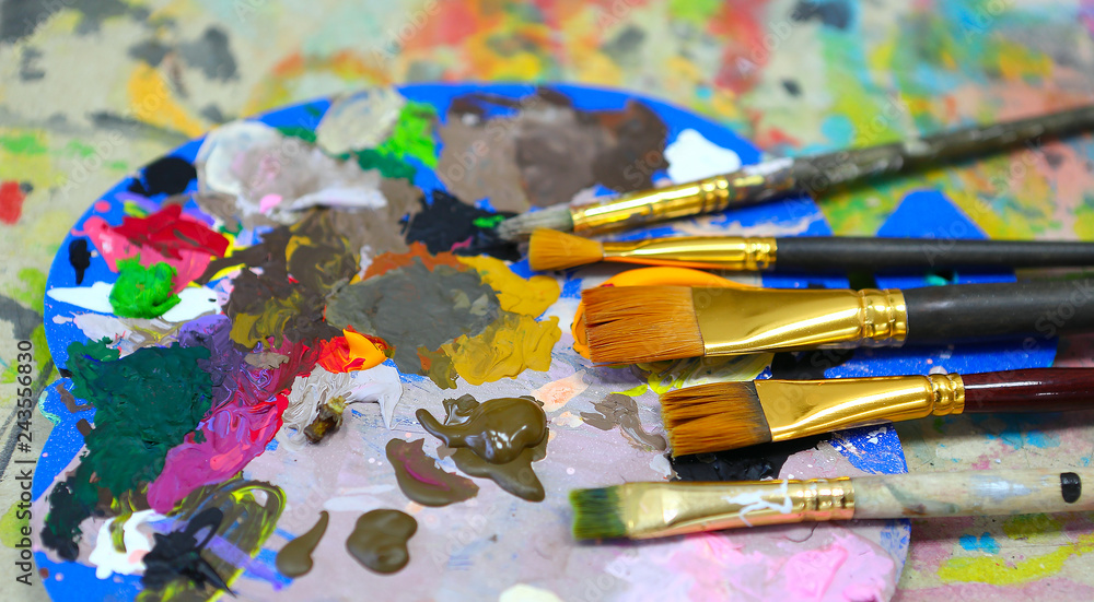 Fototapeta premium workplace painter palette with colors and brushes. Palette of colors, creative disorder, art.