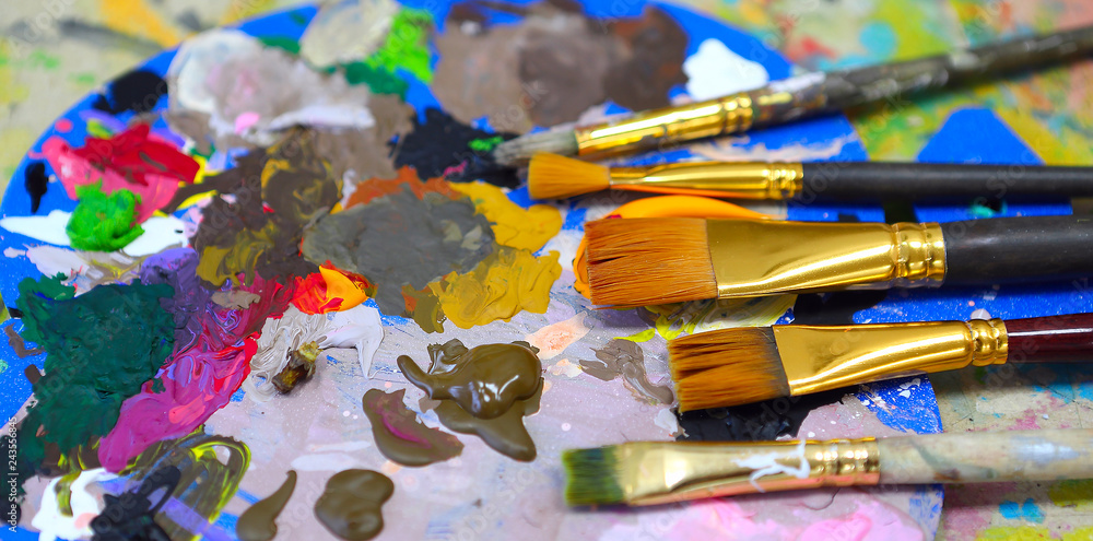 Obraz premium workplace painter palette with colors and brushes. Palette of colors, creative disorder, art.