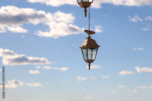 Retro lanterns outdoor, beautiful blue sky with clouds in the background.