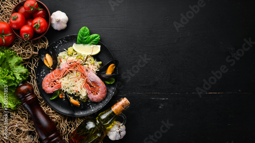 Risotto Rice with vegetables and seafood. Shrimp and mussels. On the old background. Top view. Free space for your text.
