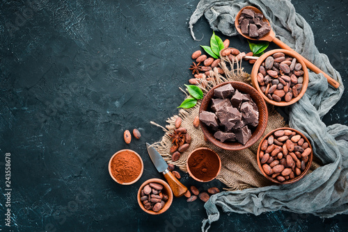 Cocoa beans, chocolate, cocoa butter and cocoa powder on a black background. Top view. Free copy space.