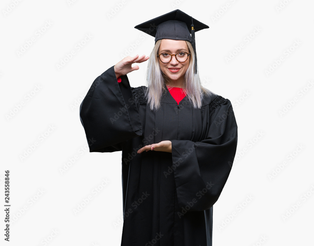 Young blonde woman wearing graduate uniform over isolated background gesturing with hands showing big and large size sign, measure symbol. Smiling looking at the camera. Measuring concept. Young blonde woman wearing graduate uniform over isolated background gesturing with hands showing big and large size sign, measure symbol. Smiling looking at the camera. Measuring concept.