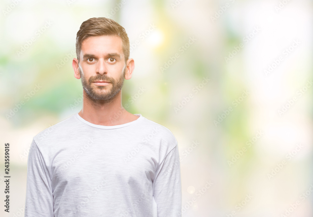 Young handsome man over isolated background with serious expression on face. Simple and natural looking at the camera. Young handsome man over isolated background with serious expression on face. Simple and natural looking at the camera.
