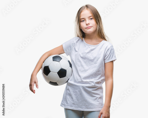 Young beautiful girl holding soccer football ball over isolated background with a confident expression on smart face thinking serious © Krakenimages.com
