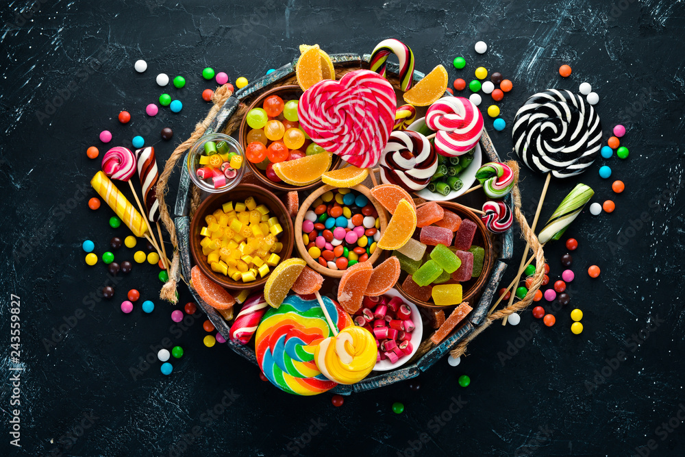 Colorful candies, jelly and marmalade in a wooden box. Sweets. On the old background. Top view. free copy space.