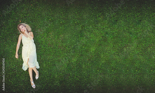 Beautiful young woman lying on the grass. Fresh natural summer concept. View from above.