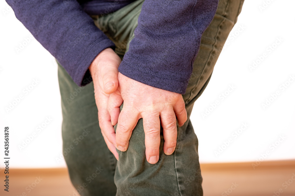 Person holds the aching knee Person holds the aching knee