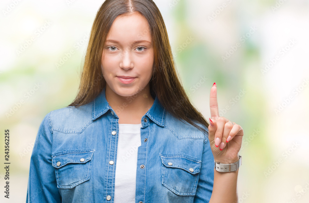 Young caucasian beautiful woman over isolated background showing and pointing up with finger number one while smiling confident and happy. Young caucasian beautiful woman over isolated background showing and pointing up with finger number one while smiling confident and happy.