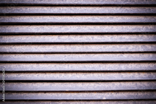 horizontal stripes of dusty metal jalousie exterior with vignette. background, texture.