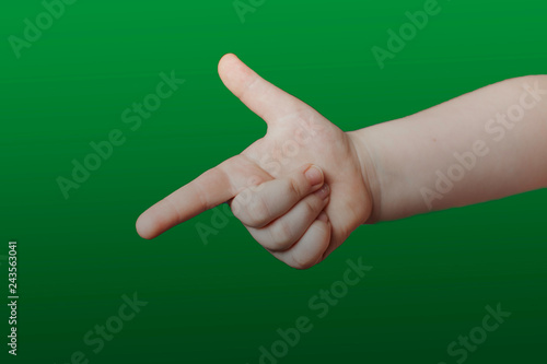 Children's hand shows a sign. Isolated on green background photo