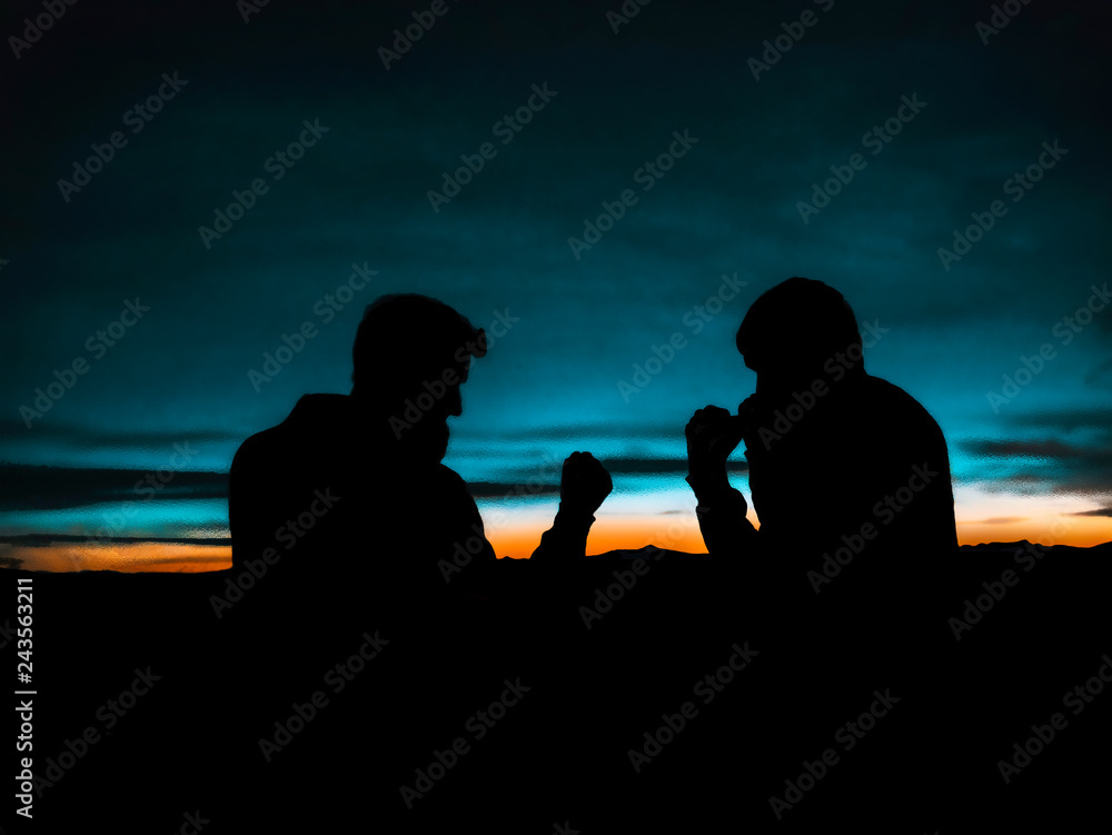 Silhouette of two fighters at sunset. Standoff